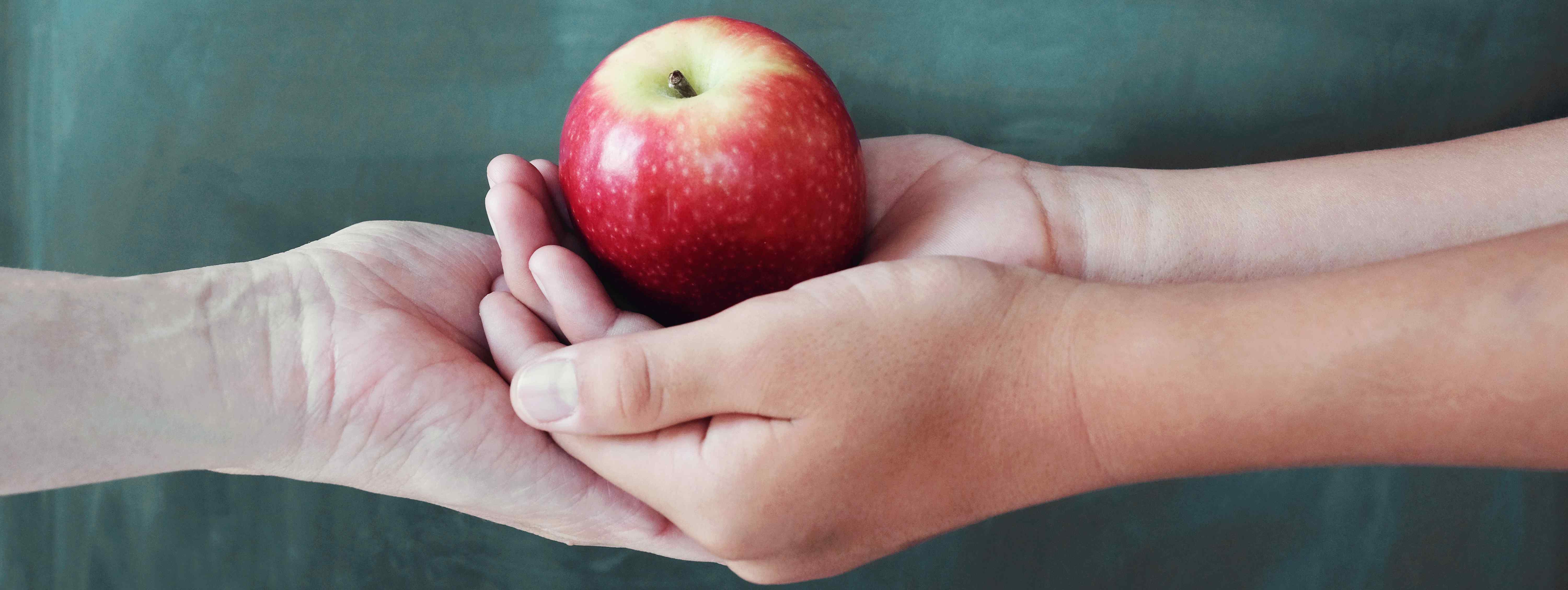 Image of hands with an apple; courtesy of Shutterstock.